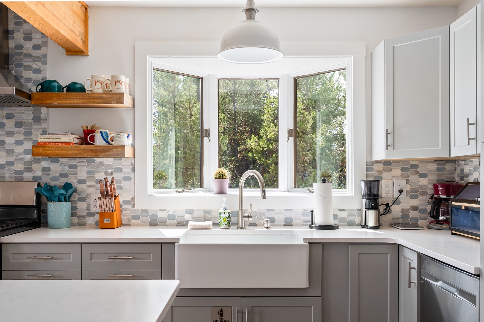 Your bright, beautifully designed kitchen awaits, with sleek countertops, modern appliances, and a cheerful garden view through large windows that fill the space with natural light.