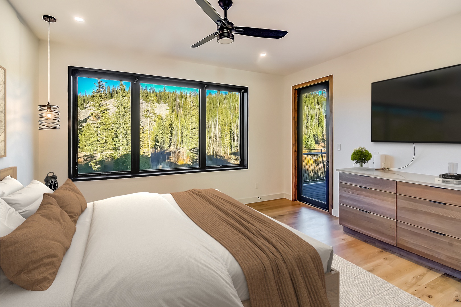 Wake up to stunning forest views through floor-to-ceiling windows in your serene bedroom retreat with modern amenities.