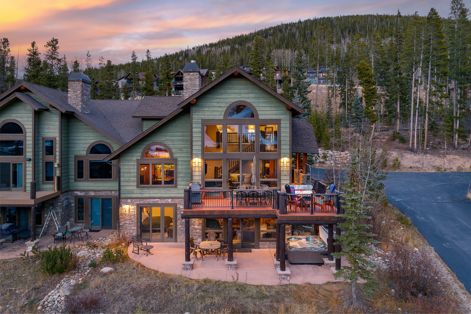 Mountain retreat featuring multiple decks and panoramic views of forested hillsides during golden hour.