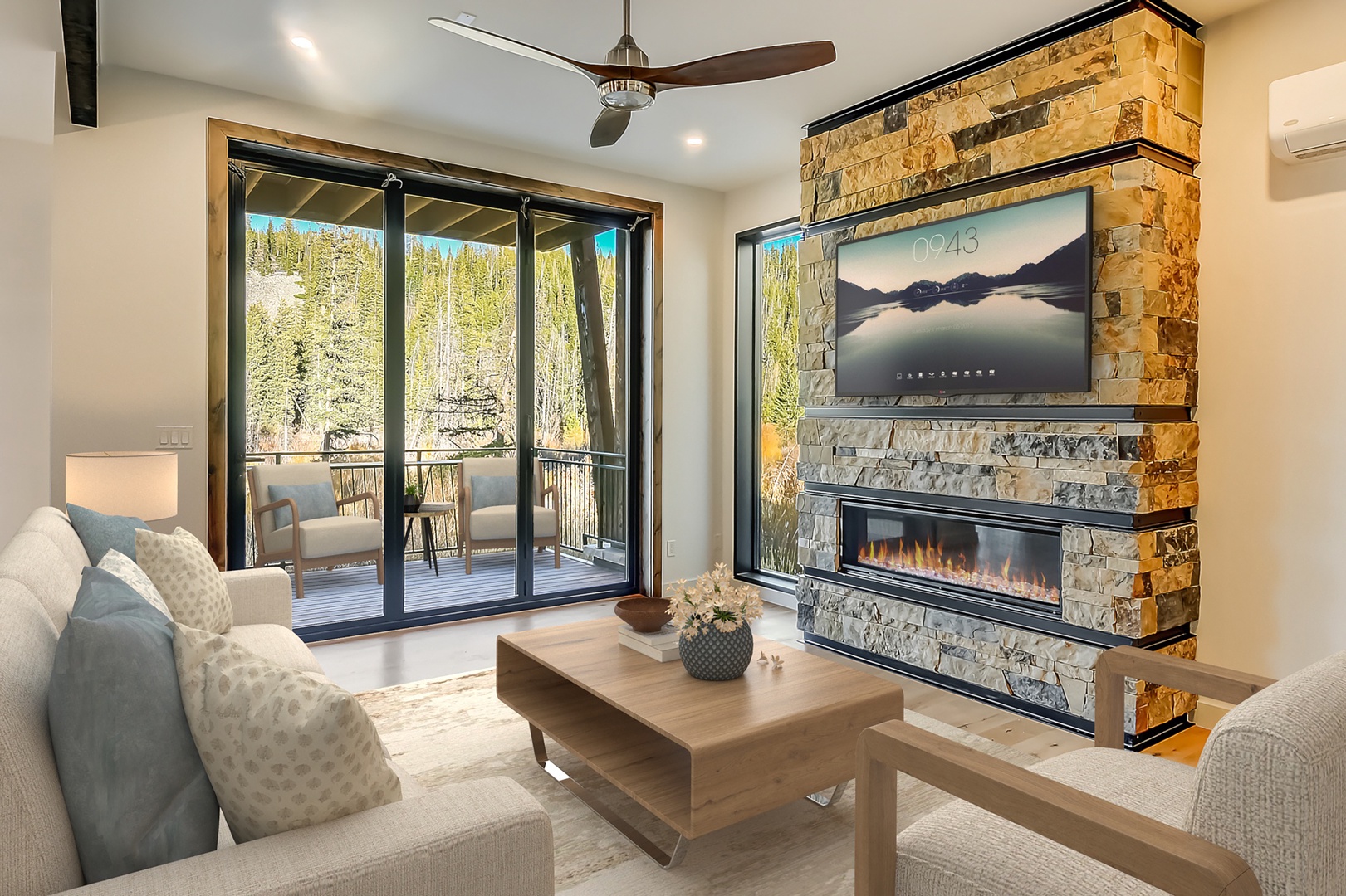 Unwind in your elegant living room with a cozy fireplace, large TV, and stunning mountain views through expansive windows.