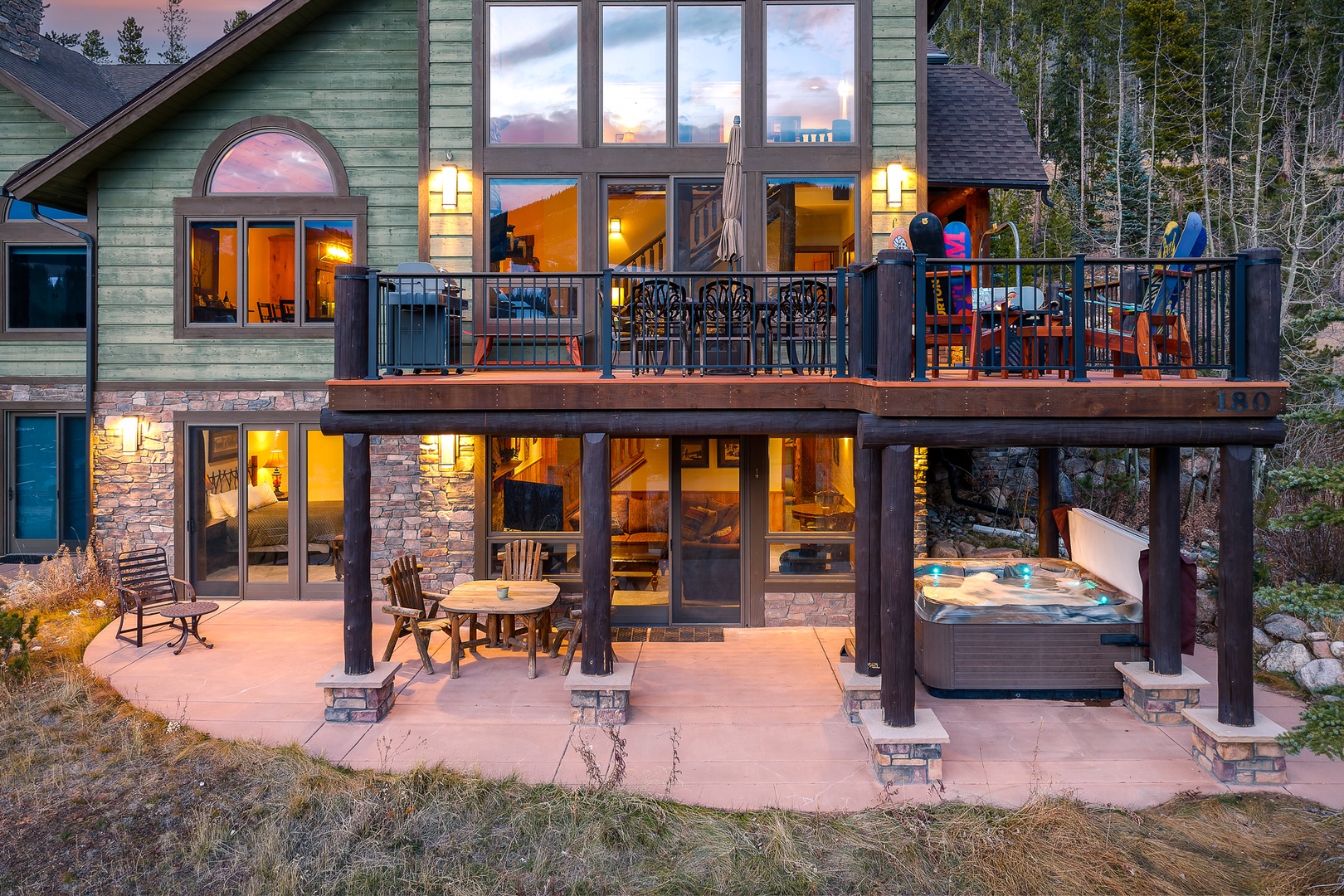 Mountain retreat with expansive deck overlooking forest. Stone and timber architecture creates rustic elegance in natural setting.