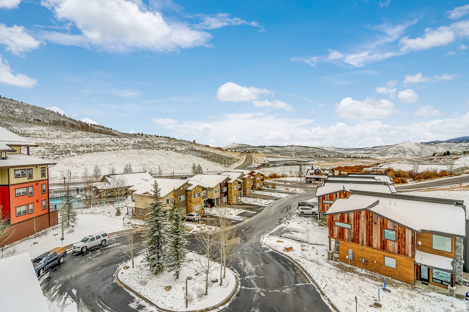 Elevated winter view showcasing the property's mountain community setting with snow-covered hills and charming residential neighborhood.