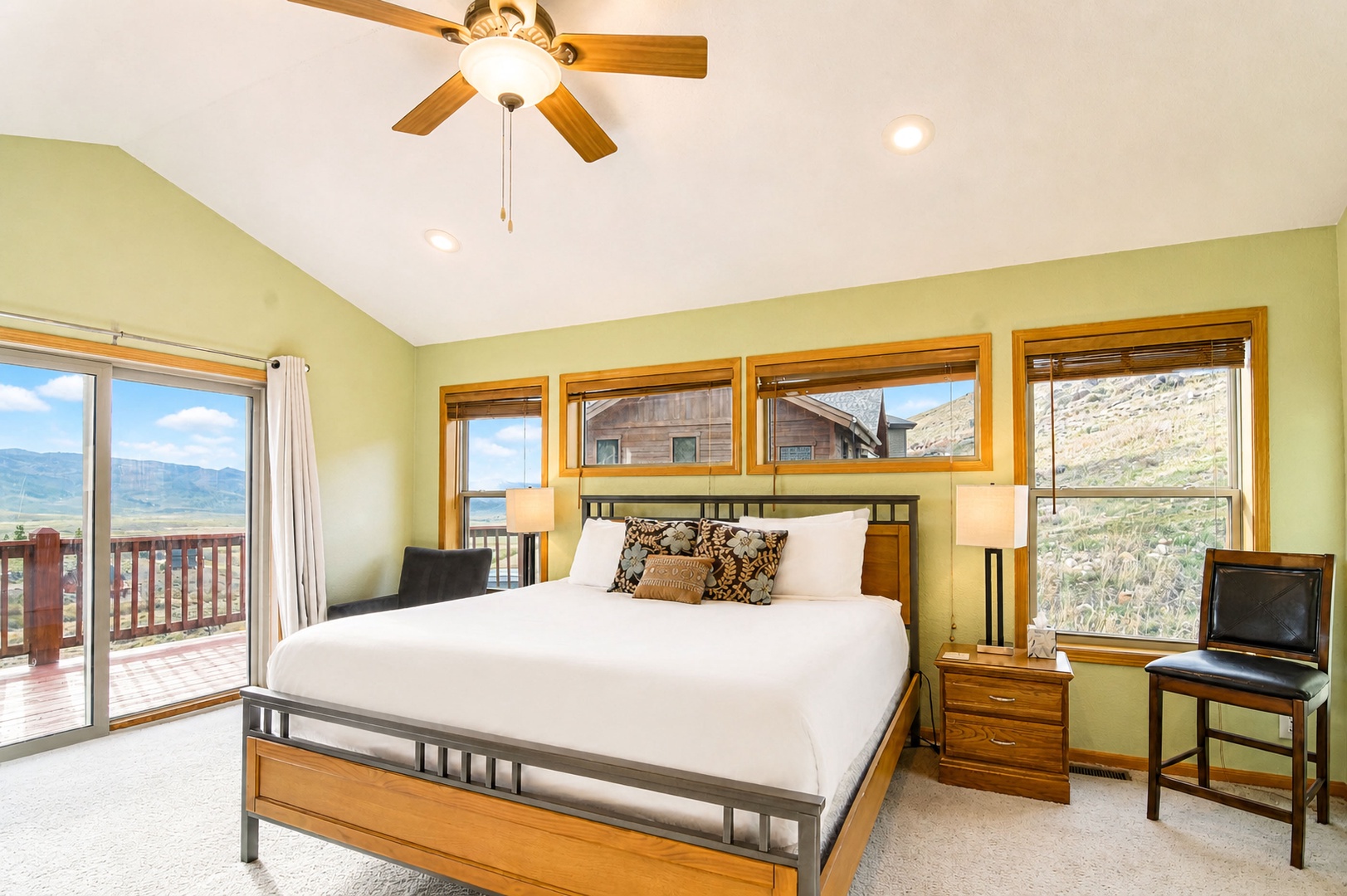 Your peaceful retreat features vaulted ceilings, wood accents, and abundant windows framing breathtaking mountain and valley scenery. Relax in this bright, airy bedroom with private deck access.