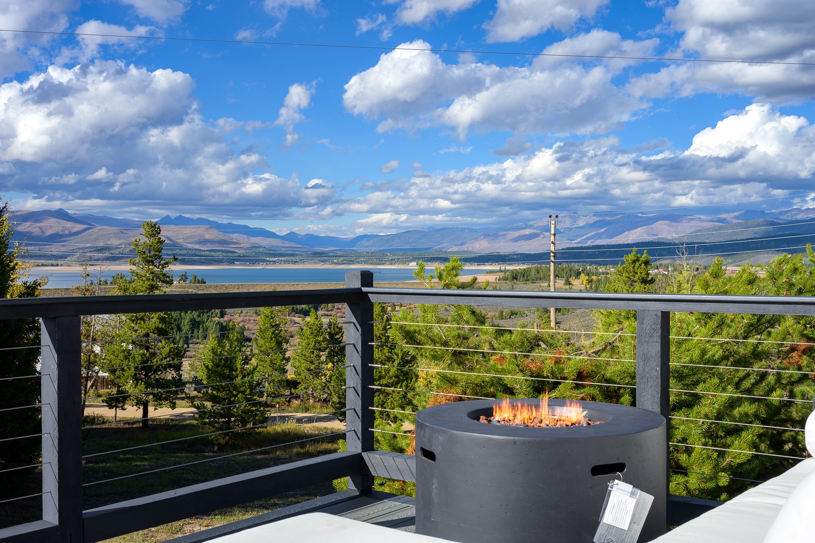 The property is located in a scenic area with sweeping views of mountains, lake, and evergreen forests stretching across the surrounding landscape.