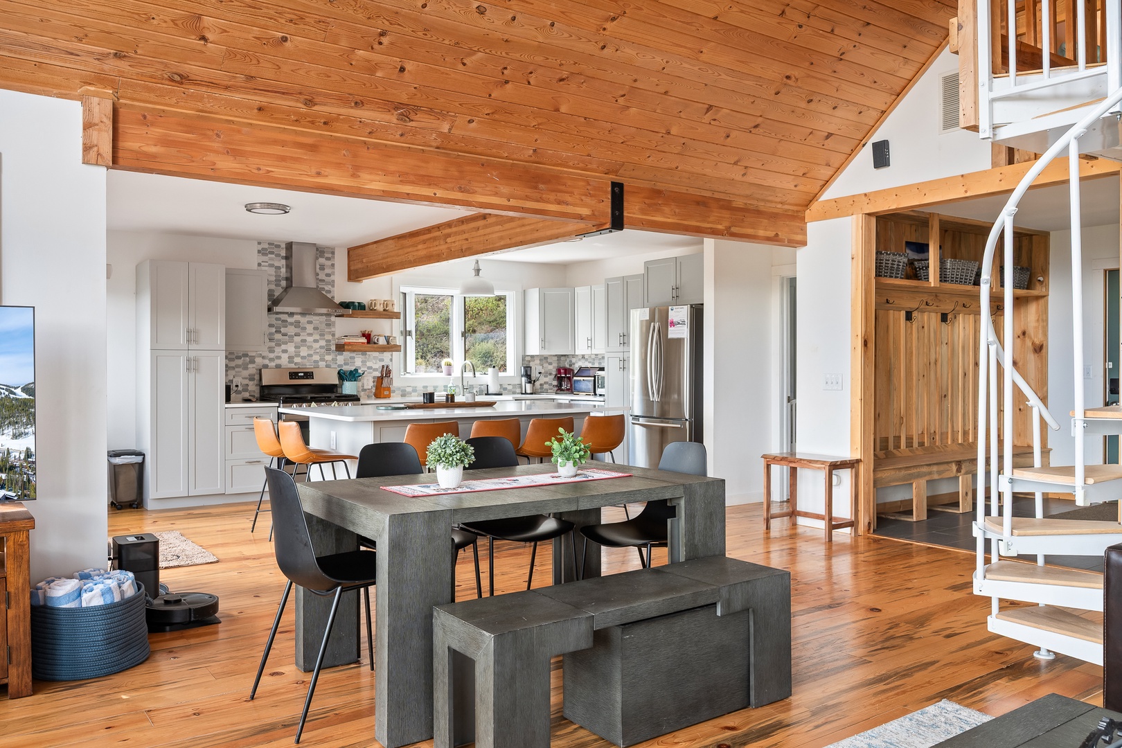 Step into your inviting open-concept retreat, where warm wood beams frame modern comforts. You'll love gathering at the spacious dining table or preparing meals in the fully-equipped kitchen, all beneath soaring vaulted ceilings.