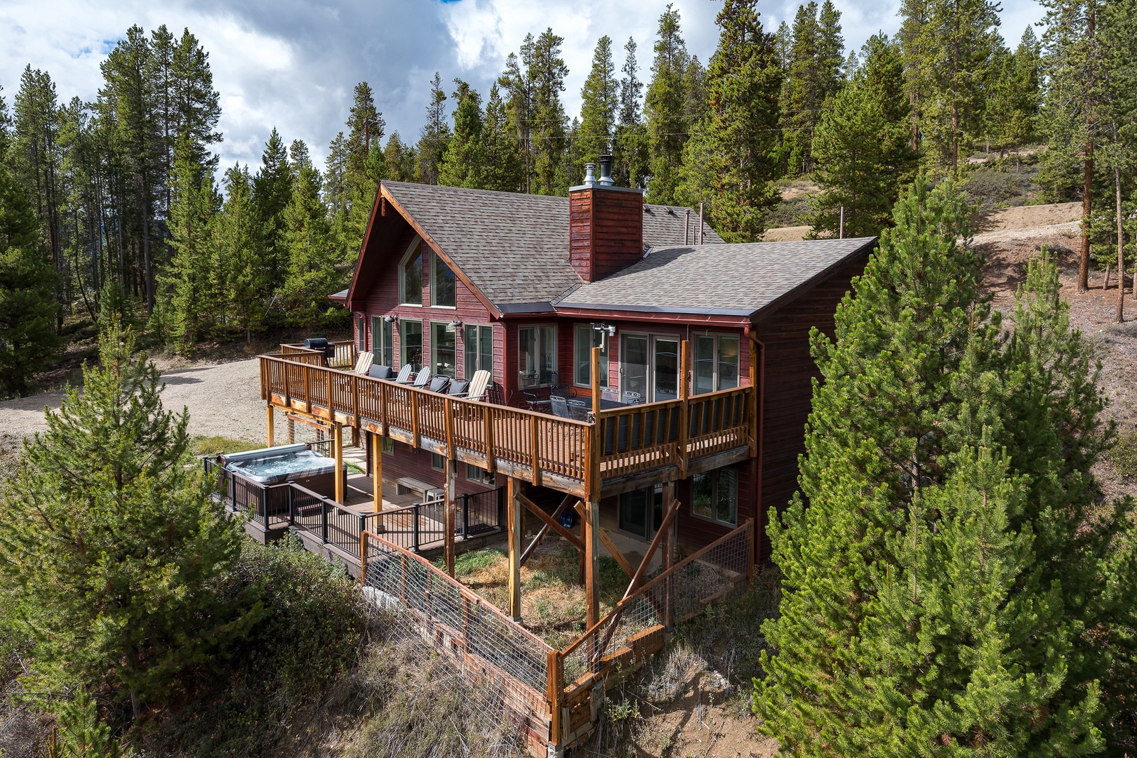 A secluded mountain retreat surrounded by towering pines, featuring multi-level decks and a private hot tub—perfect for reconnecting with nature in peaceful seclusion.