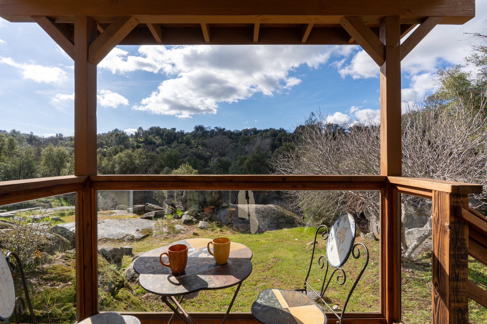 Breathtaking hillside views frame your morning coffee on this charming covered back patio.