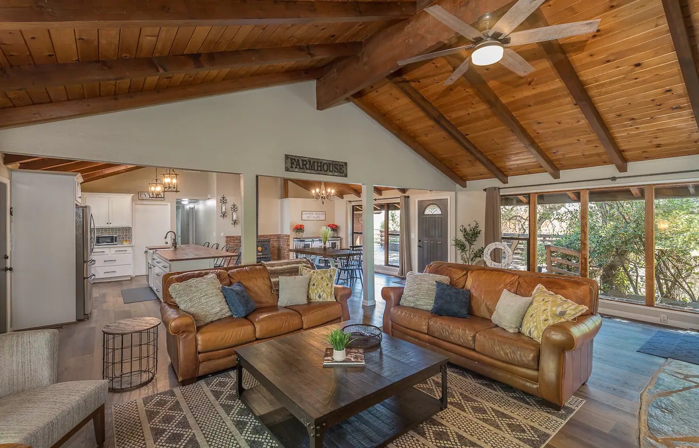 Relax in your open-plan retreat where rustic beams meet modern comfort—leather sofas invite you to unwind beneath cathedral ceilings.
