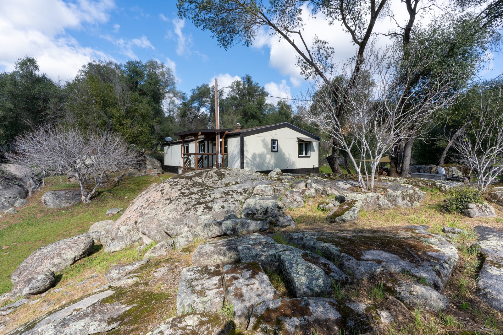 Charming cottage nestled among ancient granite boulders with natural landscape views.