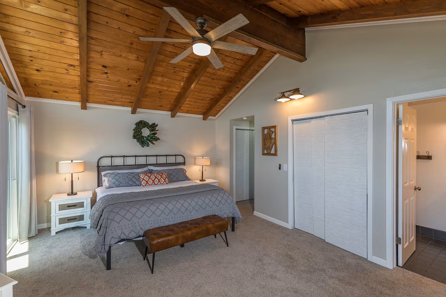 Relax under soaring wood-beam ceilings in your spacious main bedroom, where modern comfort create your perfect retreat.