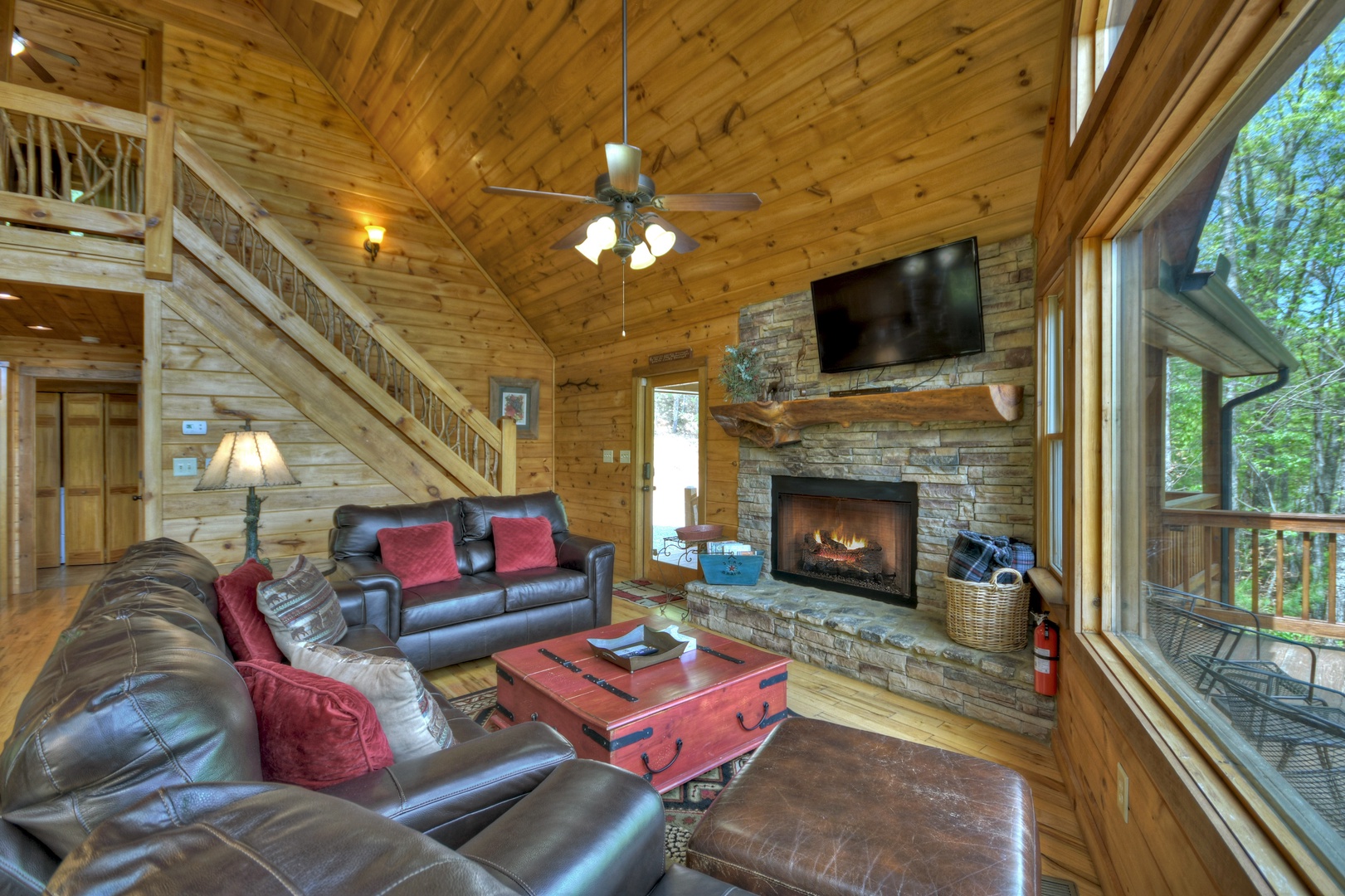 Aska Lodge- Spacious living room with rustic decor and staircase leading upstairs