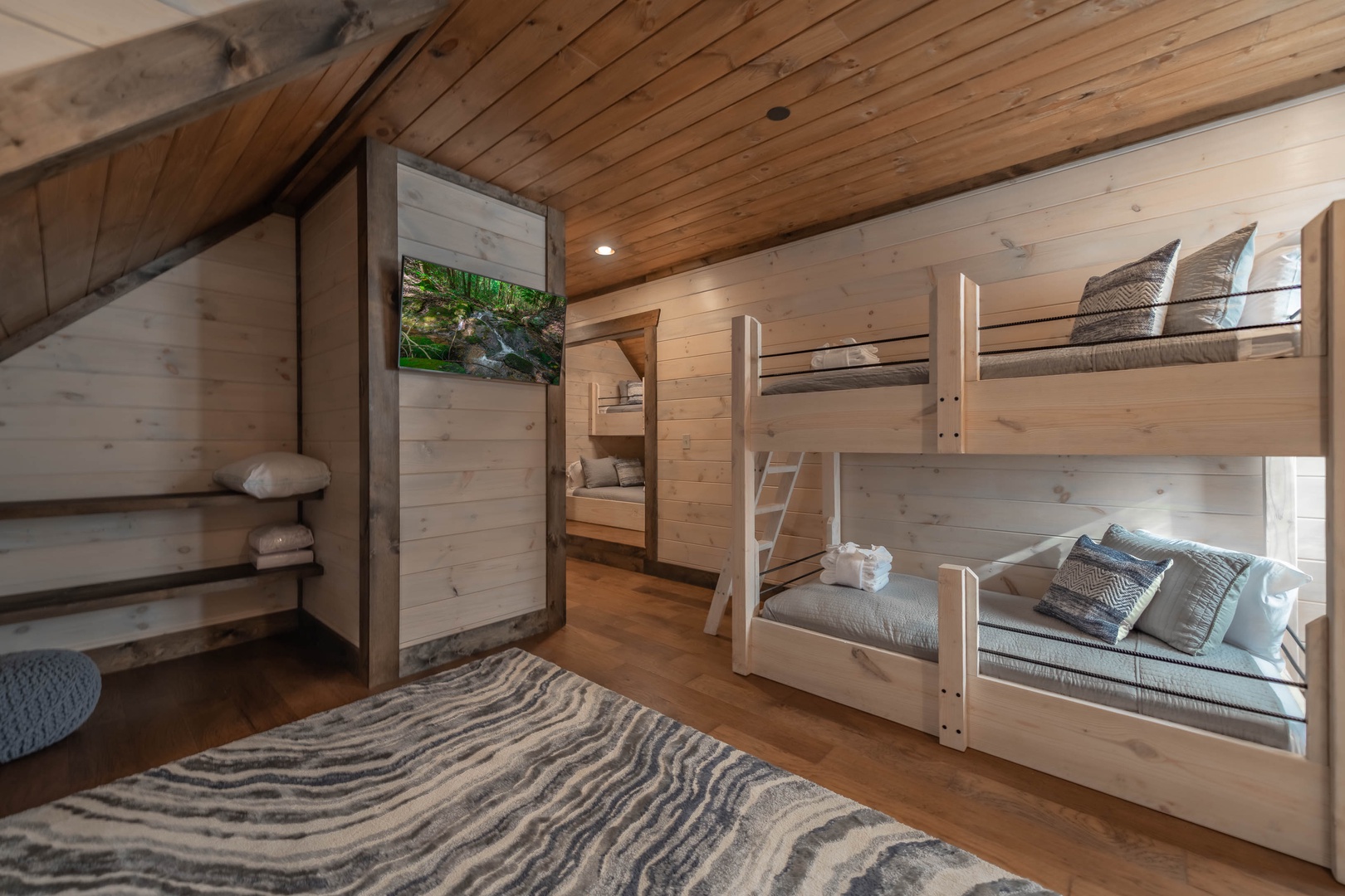 The Ridgeline Retreat- Upper level bunk room area with a mounted TV