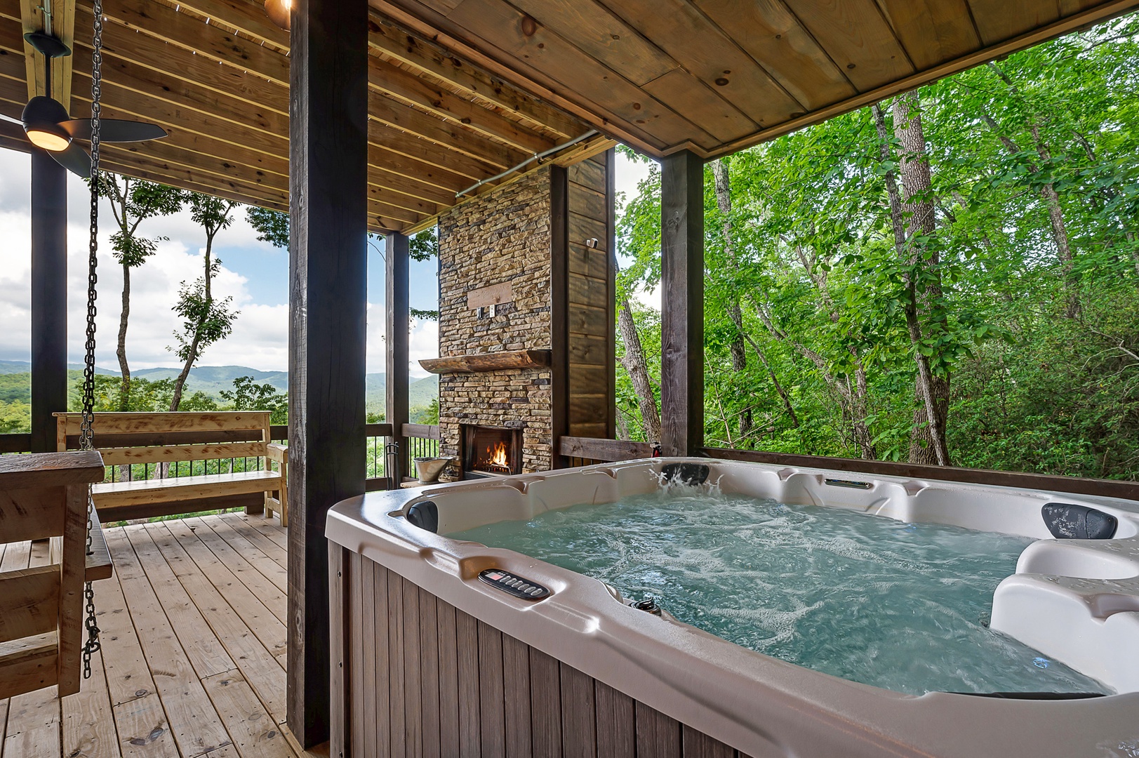 Feather & Fawn Lodge- Hot tub on the lower level deck with a fireplace