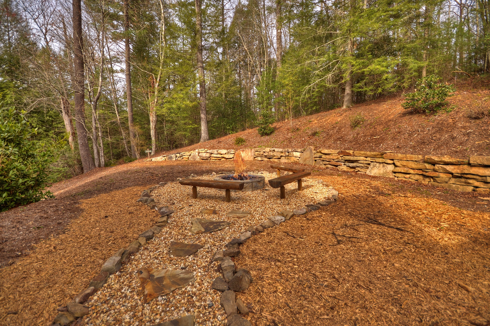 Reel Creek Lodge- Firepit area with stone walkway from the cabin