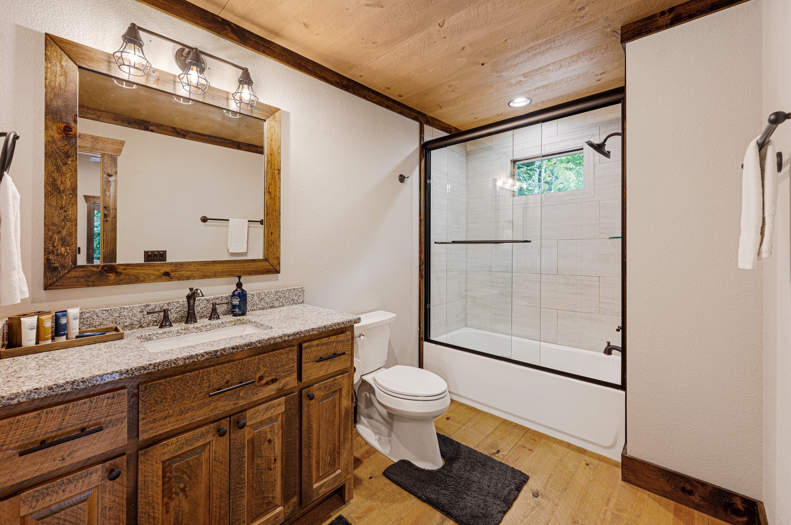 Mountain Echoes- Upper level master bathroom with vanity sink, toilet and step up shower