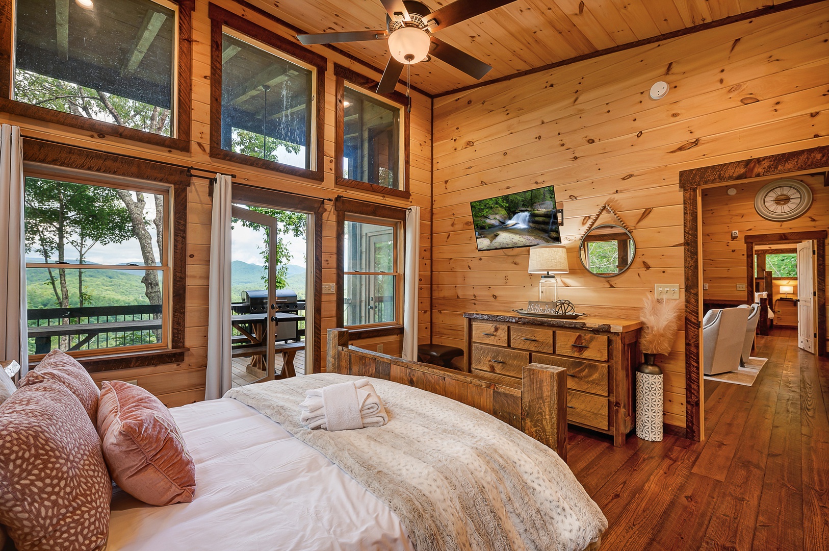 Feather & Fawn Lodge- Entry level guest bedroom with a dresser and mounted TV
