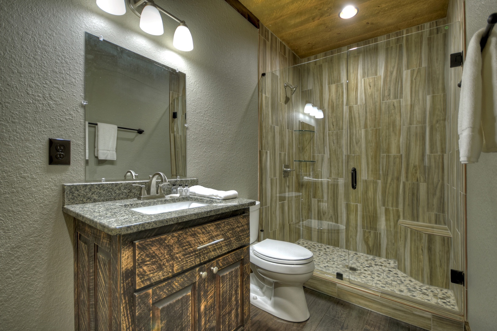 New Heights- Lower level full bathroom with a vanity sink, toilet and walk in shower