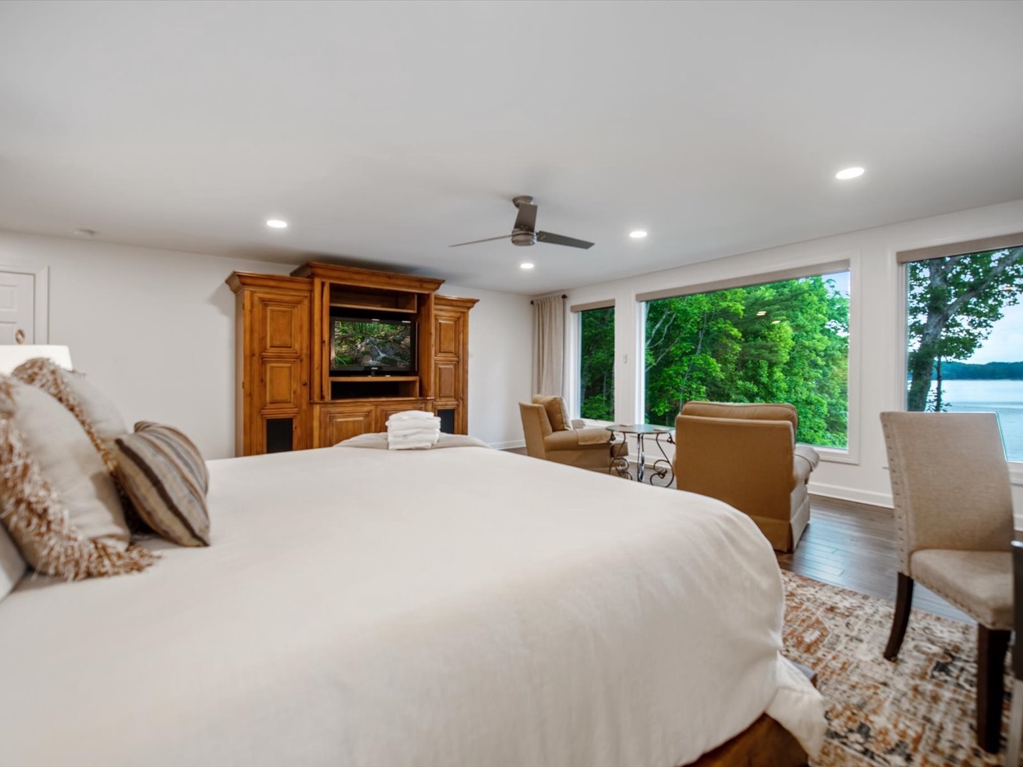 Gleesome Inn- Master bedroom with an entertainment center and TV overlooking the lake
