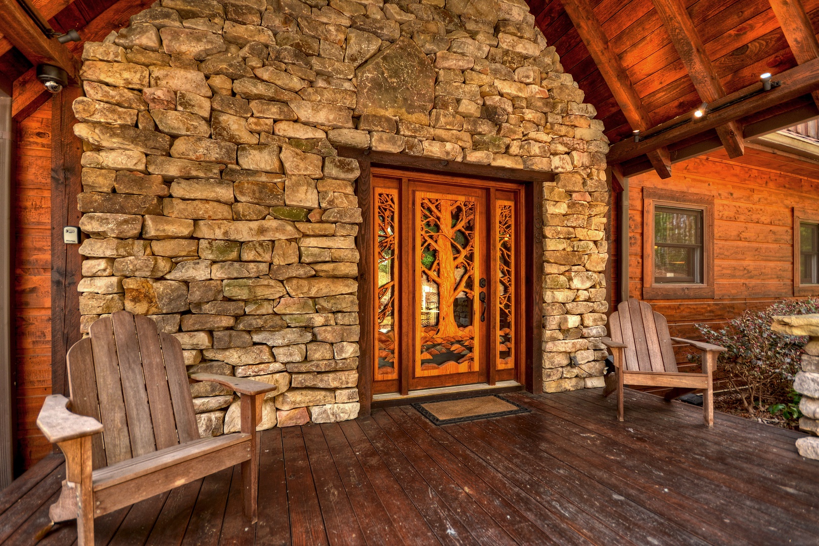 Reel Creek Lodge- Front porch area with a custom built front door