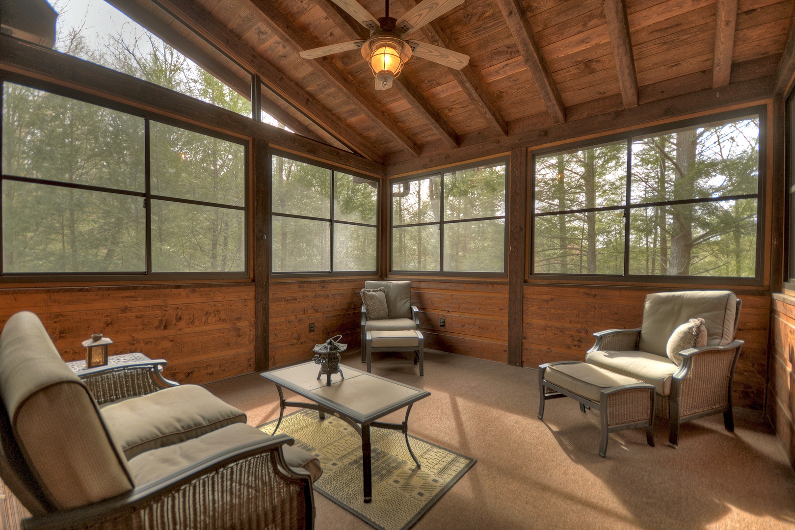 Reel Creek Lodge- Deck area with windows surrounding and outdoor seating