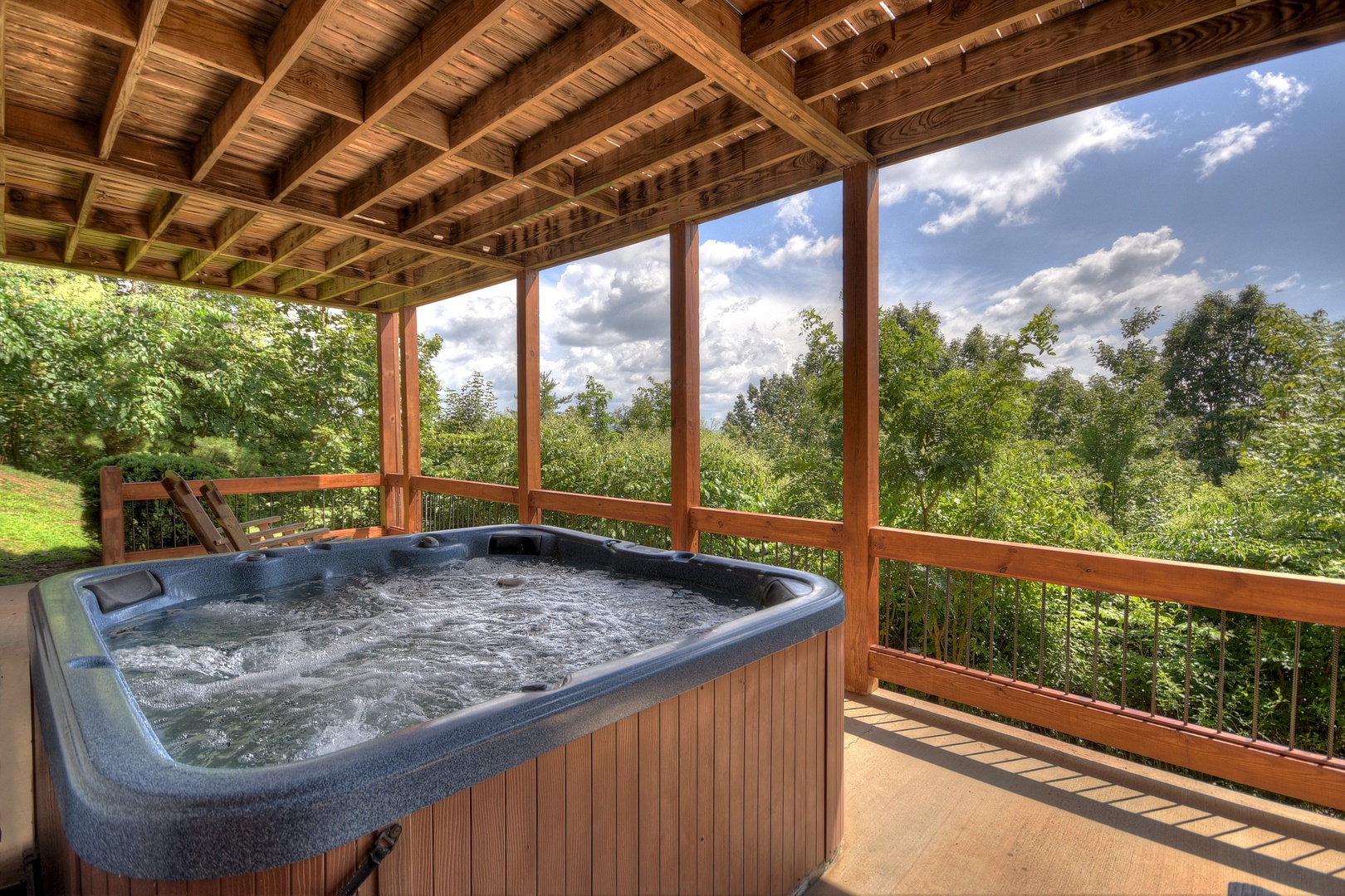 Above Ravens Ridge- Lower level patio with a hot tub