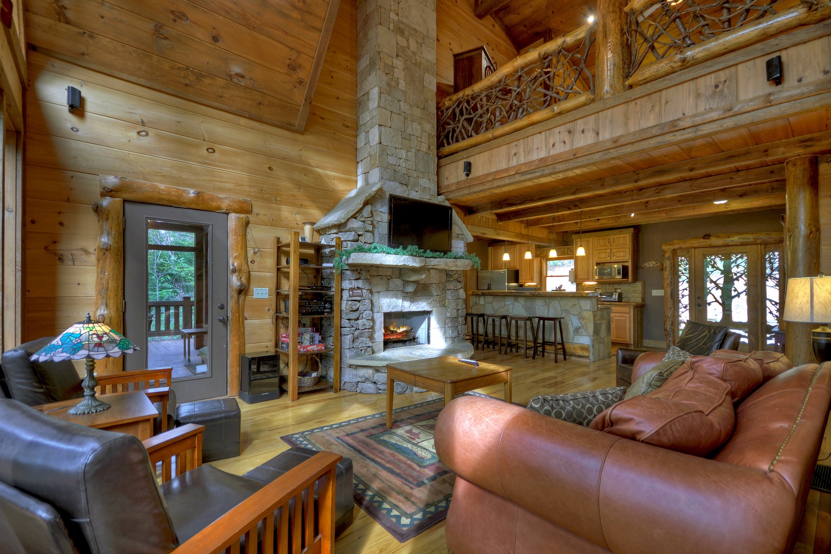 Reel Creek Lodge- Living room area with deck access and loft views