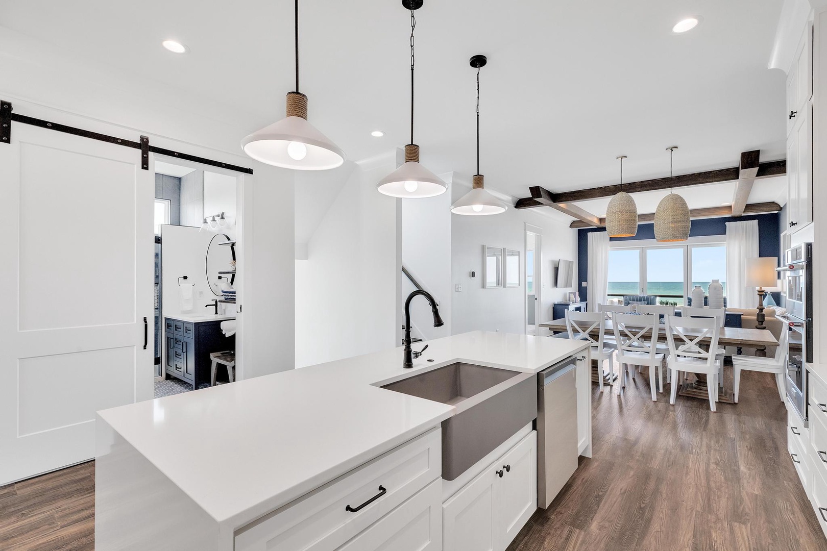 Cook your favorite meals in this bright kitchen featuring a sleek island, modern appliances, and stunning sea views. Natural light floods the open dining area where you'll enjoy meals with loved ones.