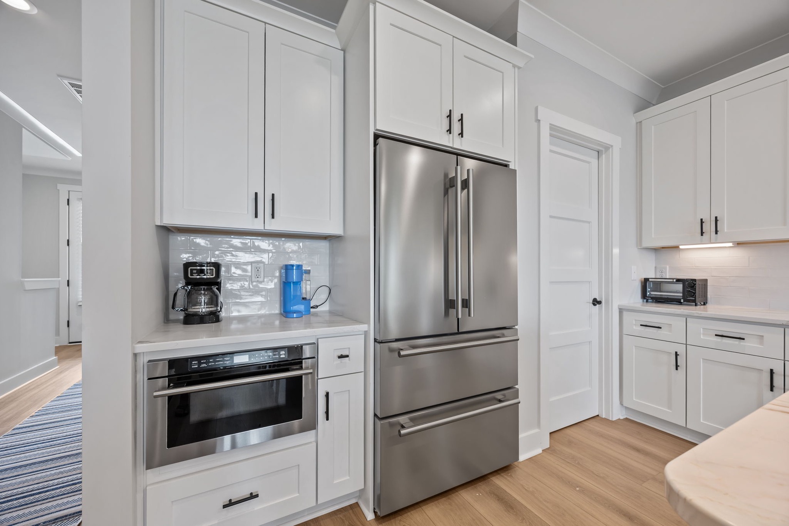 Your modern kitchen features sleek white cabinetry, stainless steel appliances, and thoughtful touches like built-in coffee stations for perfect morning routines.