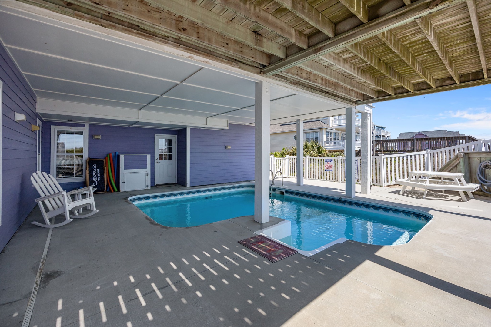 Dive into your private oasis with this covered pool deck, perfect for swimming and lounging while staying shaded from the sun.