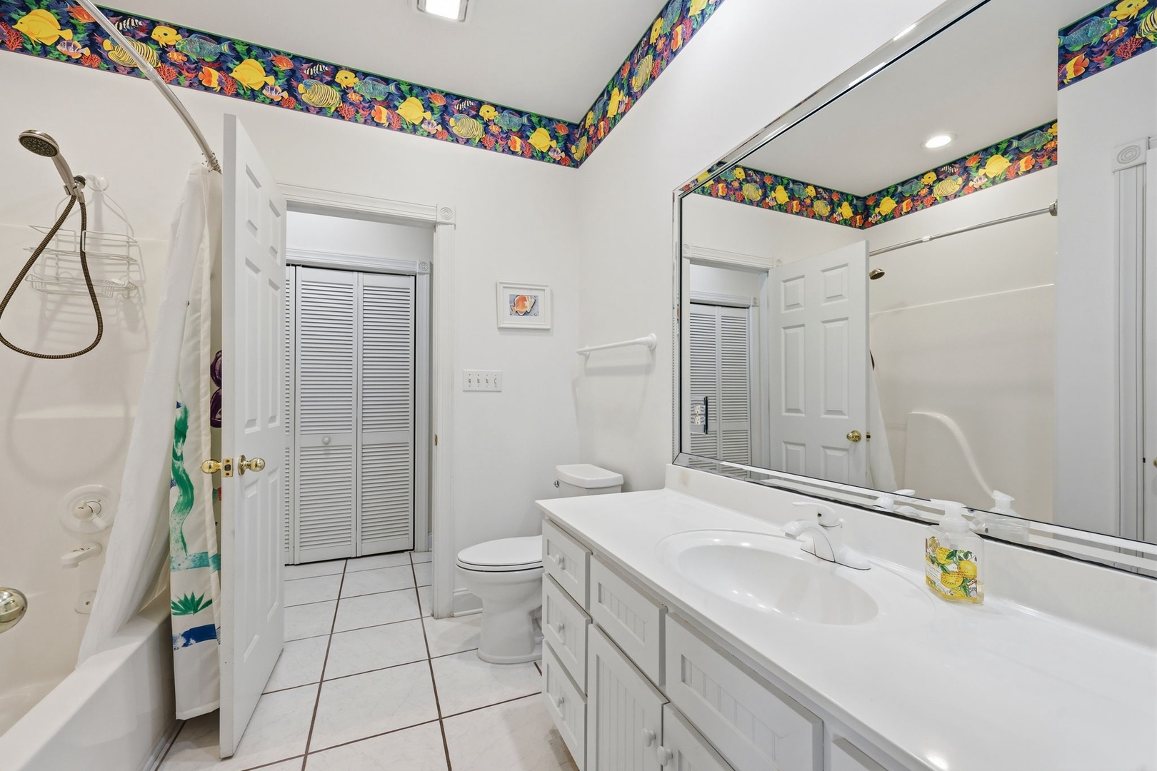 Bright bathroom with cheerful tropical accents, dual sinks, and a tub-shower combo—your refreshing retreat after a day of island adventures.