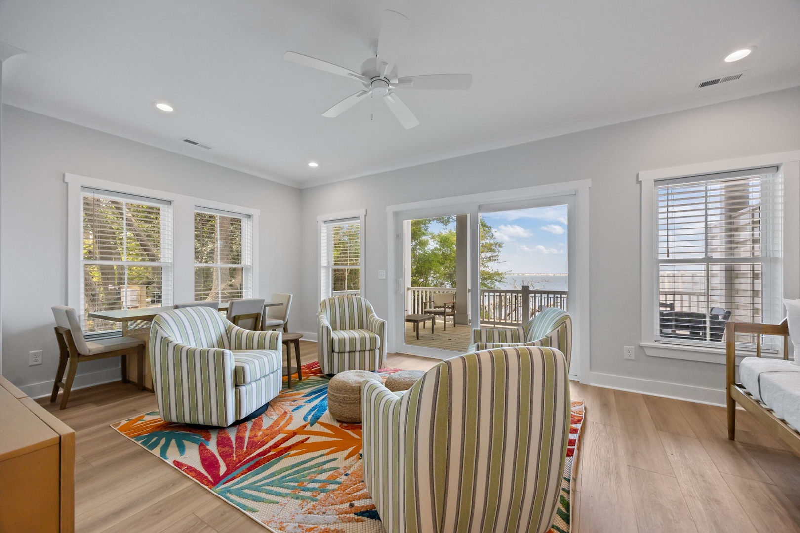 Relax in your bright living space with striped seating, colorful rug, and French doors opening to your private deck with scenic views.