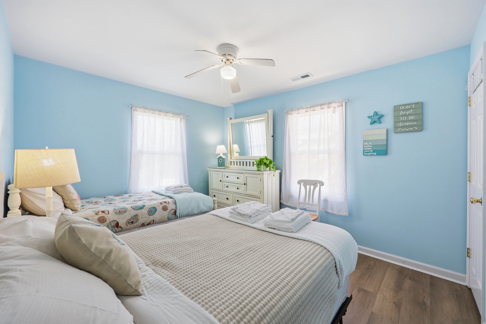 Step into your serene coastal retreat with soft blue walls, comfortable beds dressed in crisp linens, and nautical accents that invite peaceful relaxation after a day of adventure.