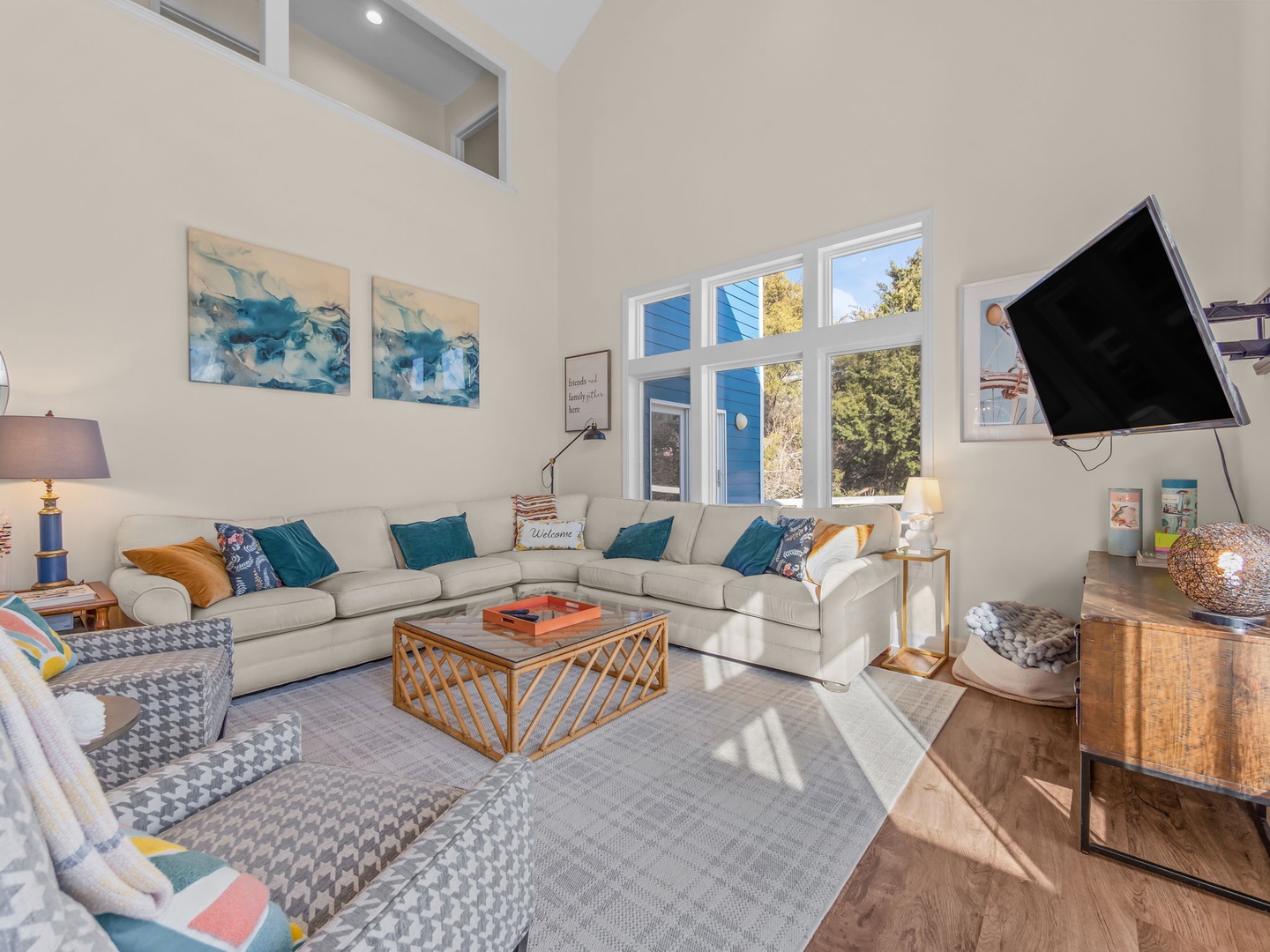 Relax in your spacious living room with plush sectional seating, natural light streaming through large windows, and modern entertainment setup for cozy evenings.