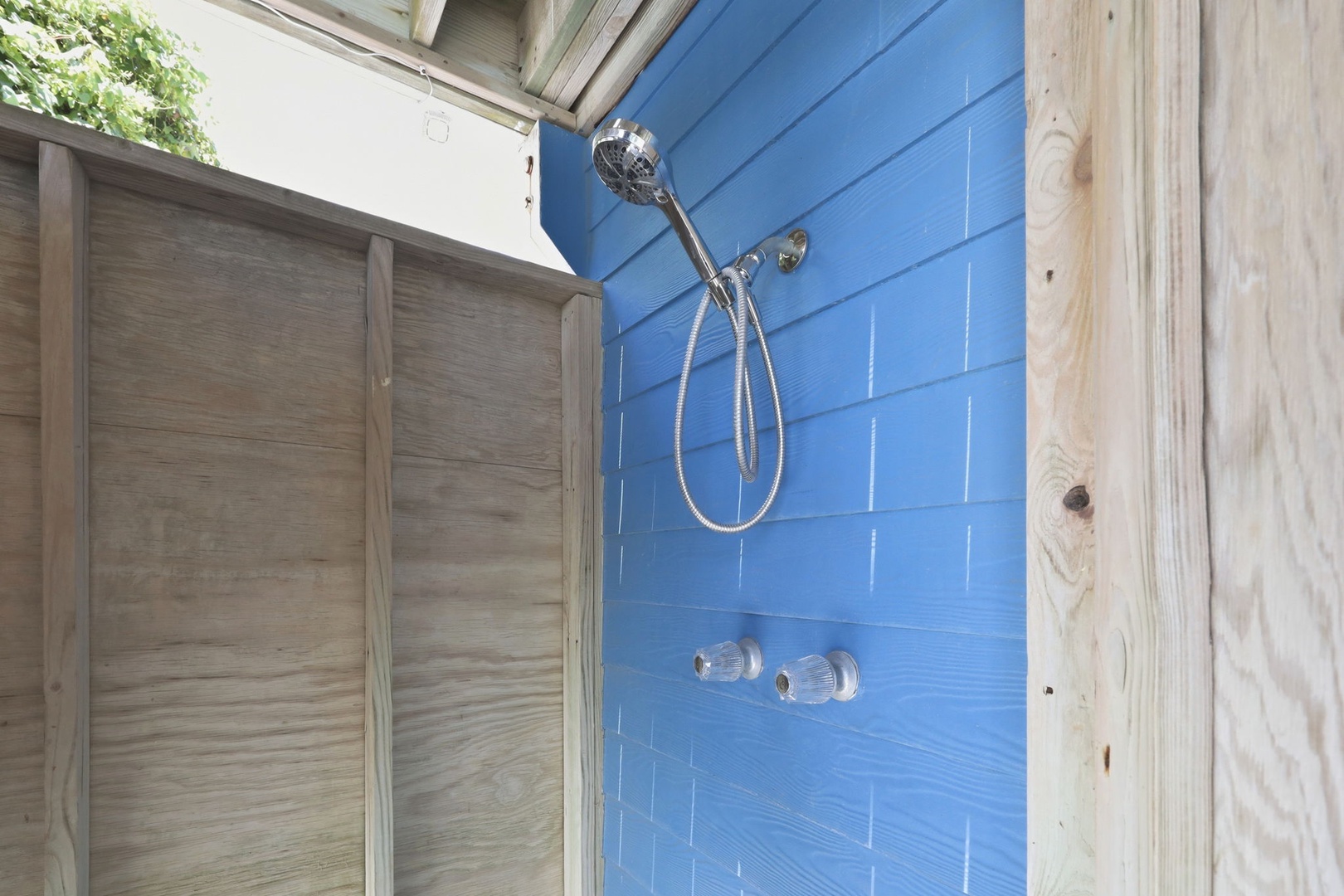Rinse away the day in your private outdoor shower, complete with a rainfall head and cheerful blue tile that captures the coastal vibe.