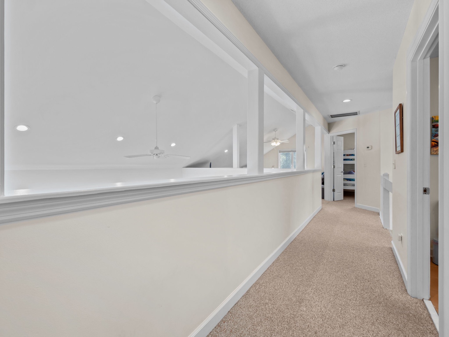 Walk through your bright, airy hallway with elegant white walls and soft carpeting beneath your feet.