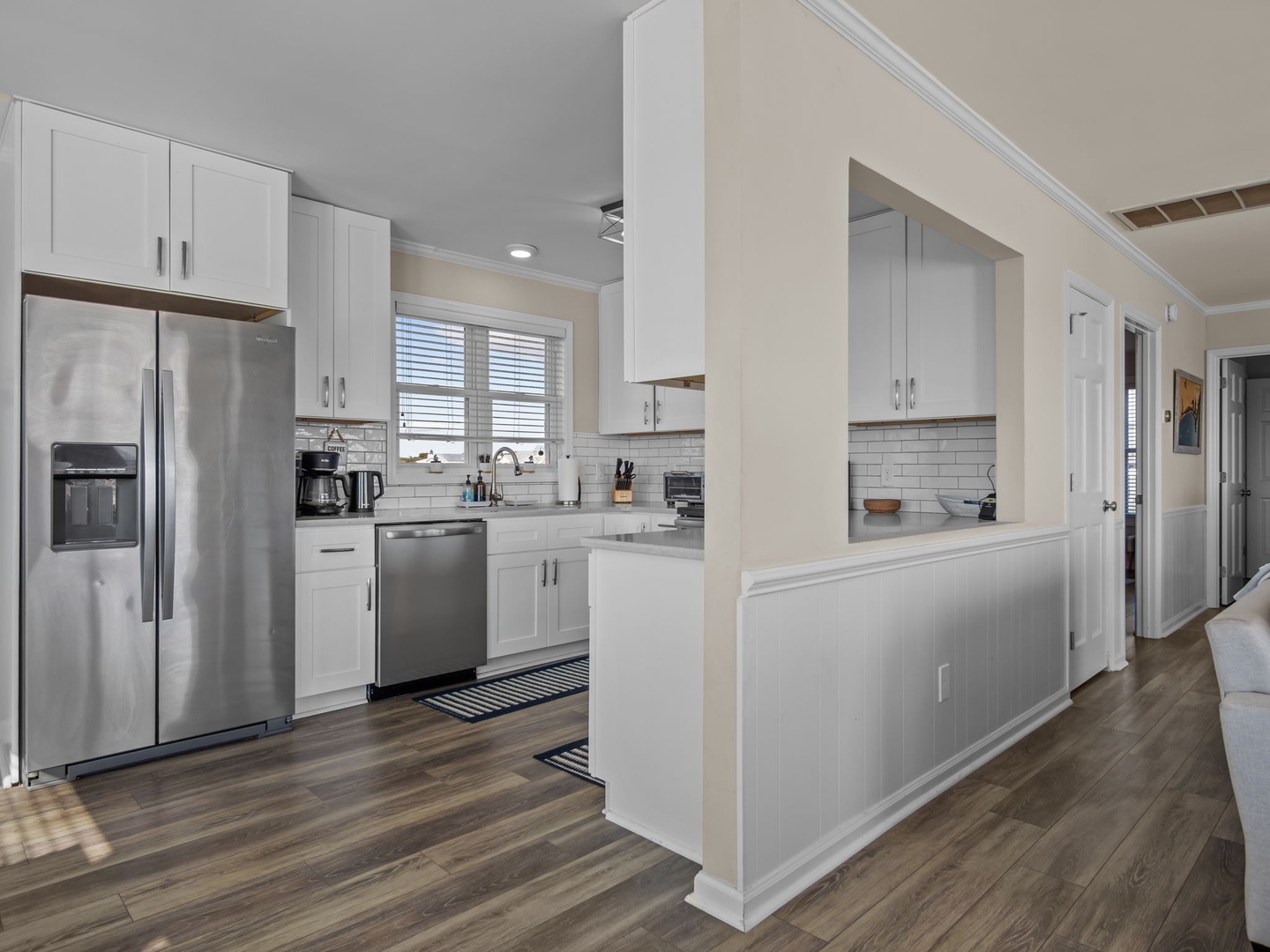 Your fully equipped kitchen awaits with modern appliances, crisp white cabinets, and a convenient breakfast bar for morning coffee.