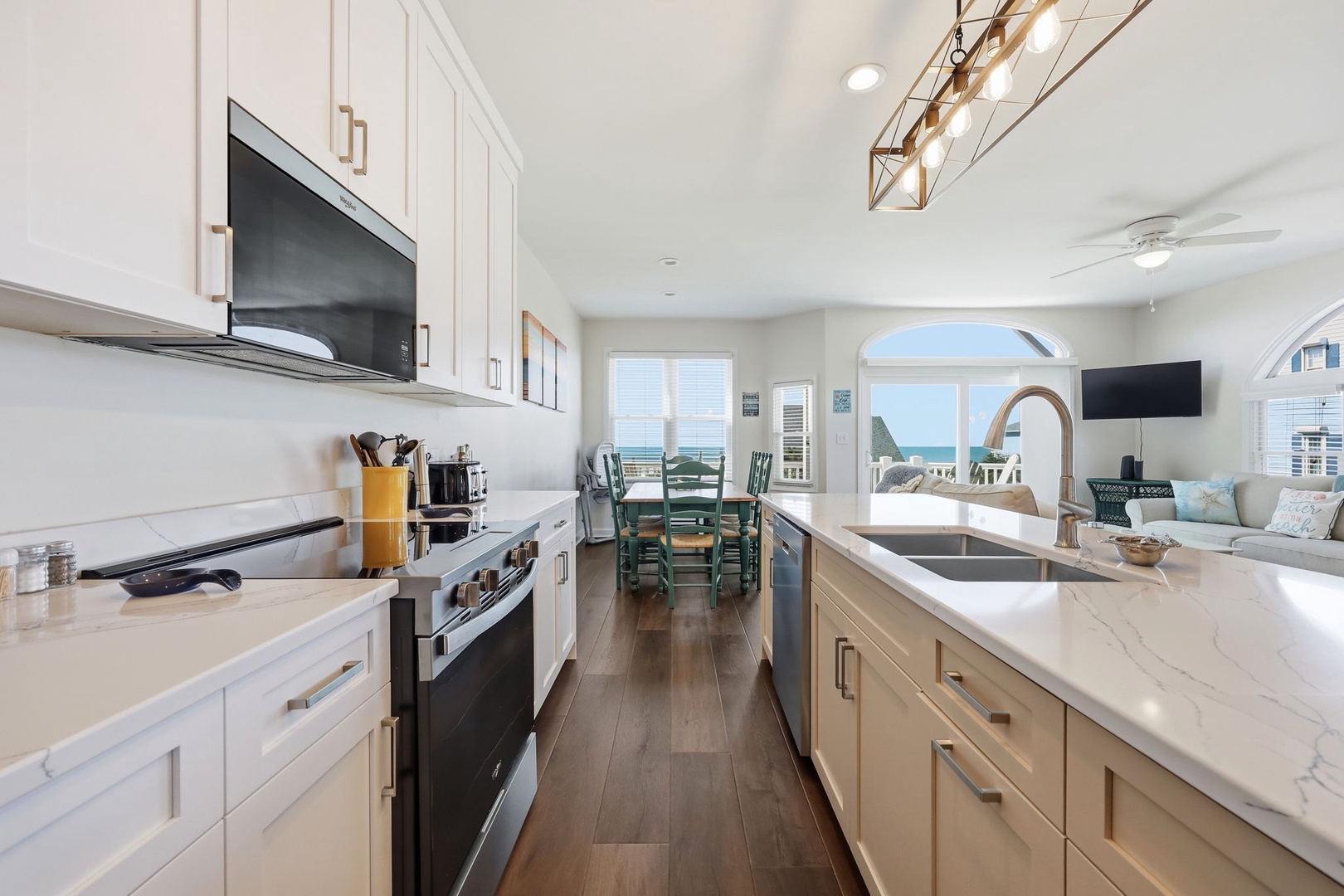 Cook your favorite meals in this bright, fully-equipped kitchen with modern appliances and gorgeous ocean views that extend seamlessly into the dining and living areas.