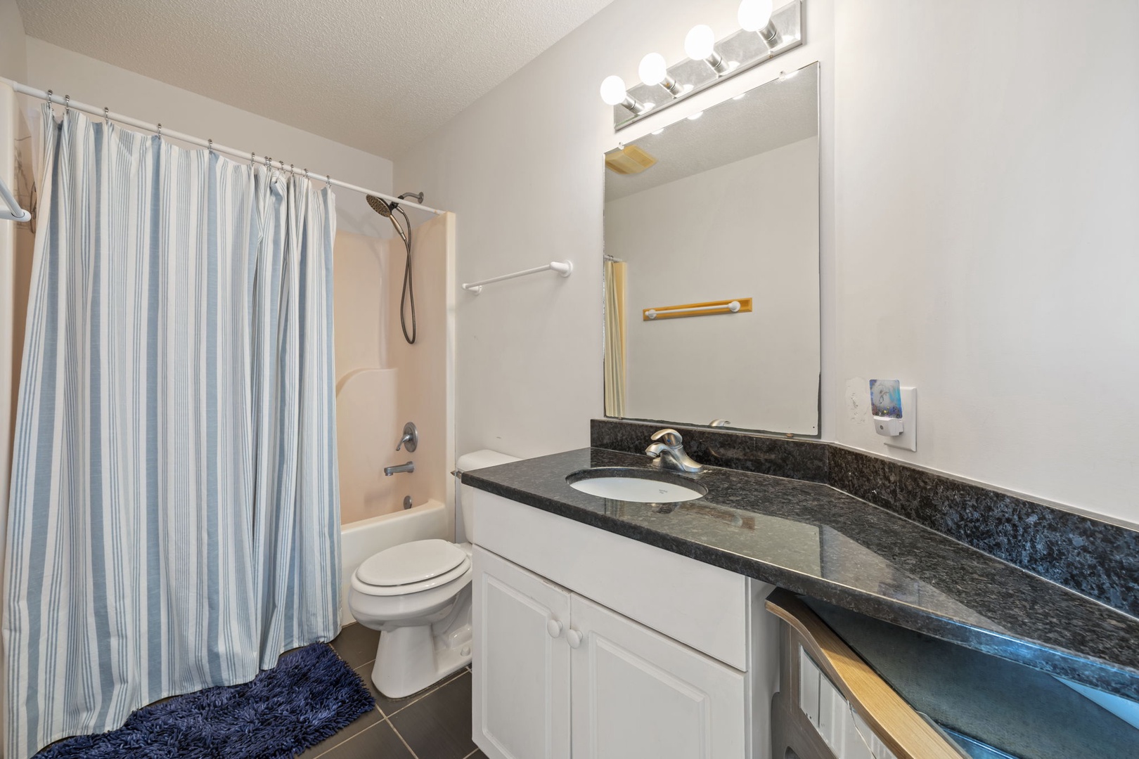 Refresh in your private bathroom with granite counters, spacious tub, and bright vanity lighting.