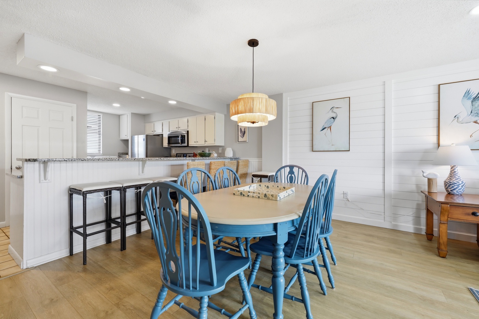 Gather around the charming coastal dining table with seating for six, perfectly positioned between your fully equipped kitchen and bright, beach-inspired living space for effortless entertaining.