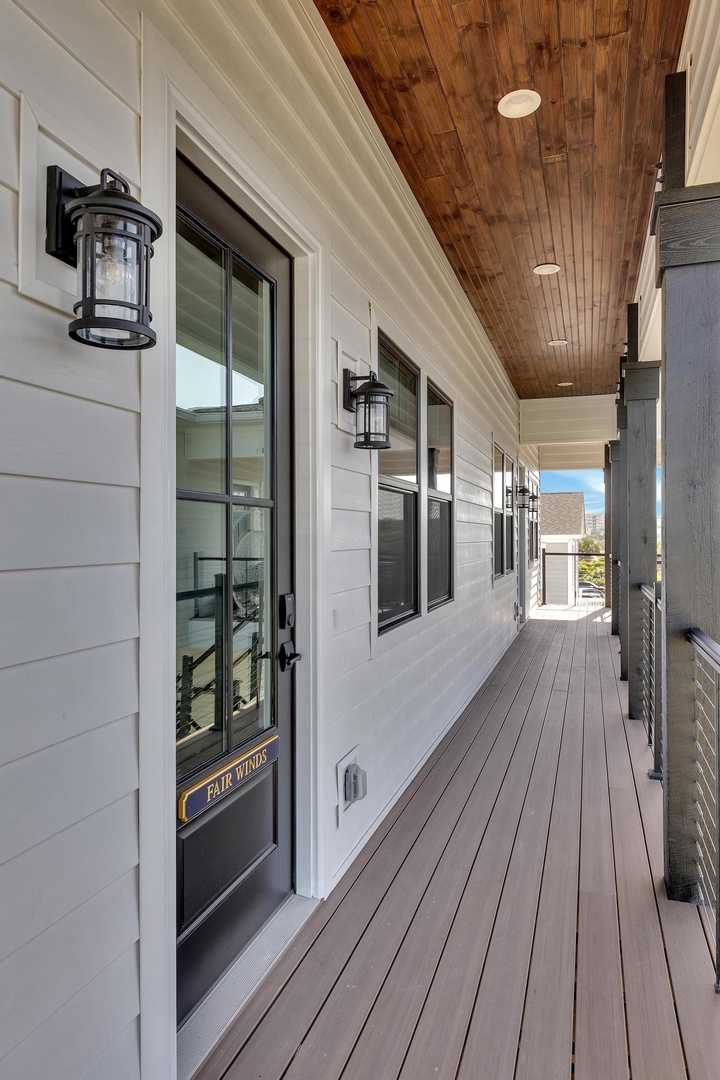 Step onto this welcoming covered deck with warm wood ceilings and ambient lanterns lighting your way to the front door.