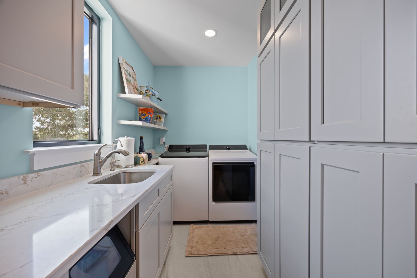 Your bright, modern kitchen features sleek cabinets, quartz counters, and everything needed for home-cooked meals during your stay.