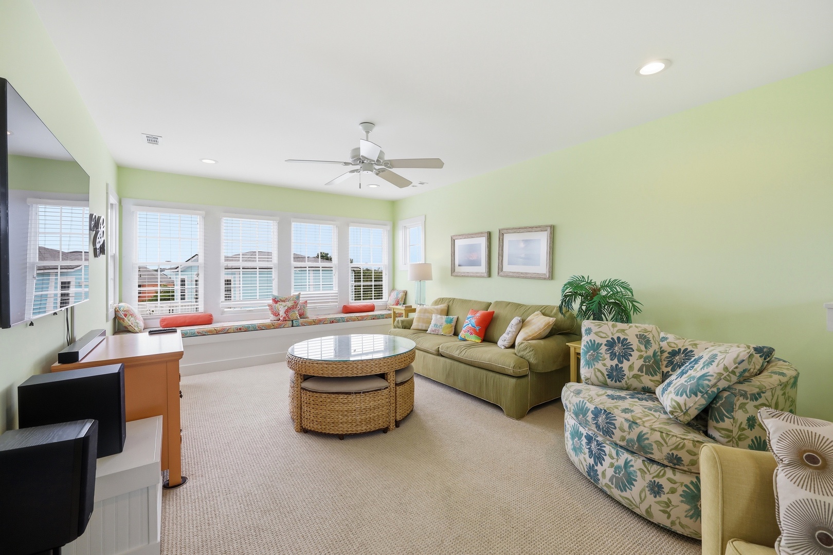 Kick back in this cheerful living room where soft green walls, comfy seating, and a window seat overlooking the water invite you to relax and unwind.