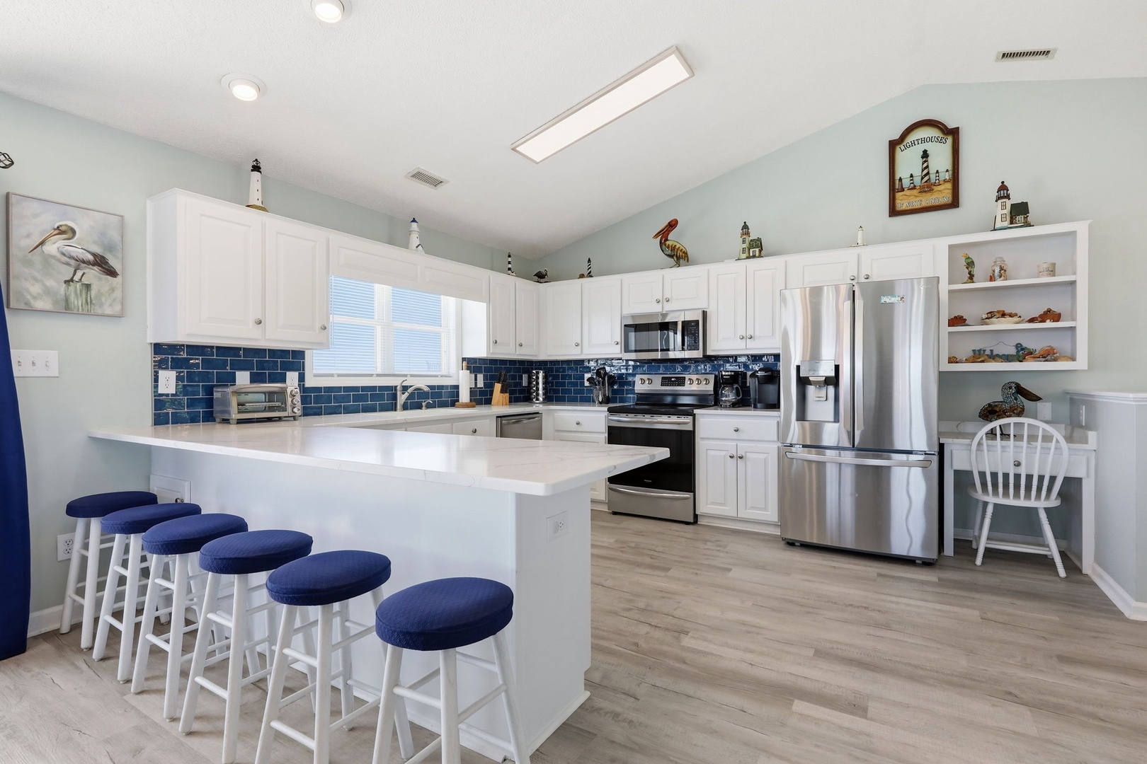 Gather around the spacious island with seating for five in this bright, coastal-inspired kitchen where you'll love preparing meals with modern appliances and ample counter space.