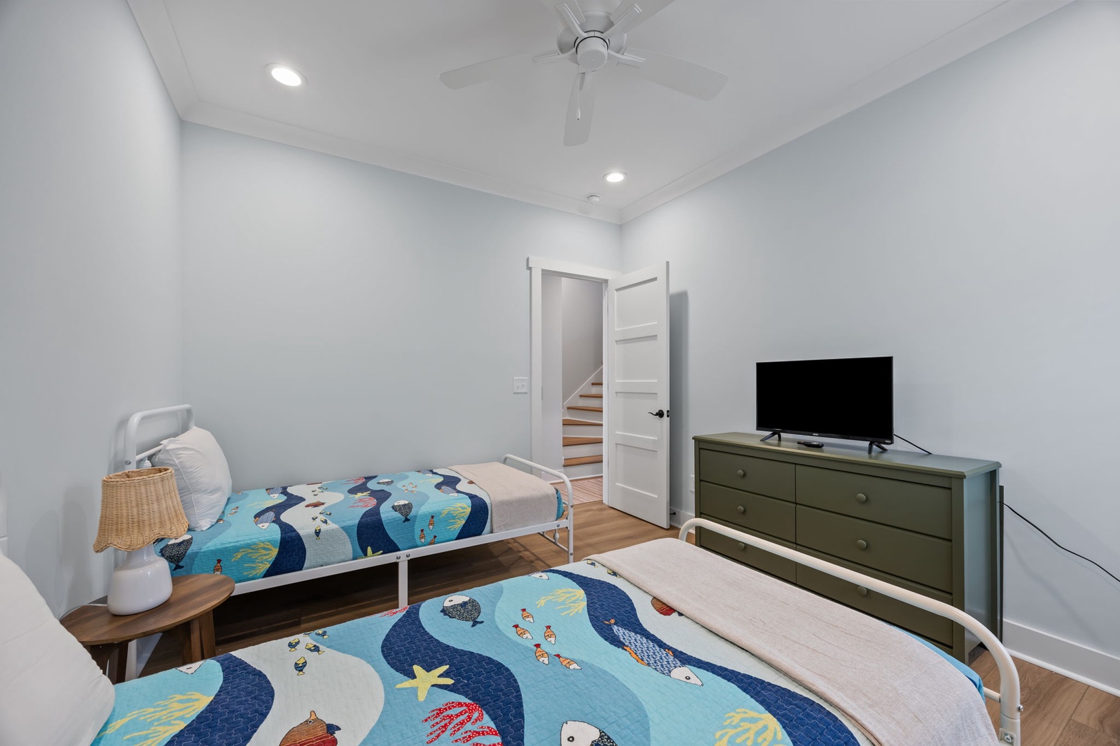 You'll love the fun ocean-themed bedding in this bright bedroom, perfect for kids with twin beds and a TV for movie nights.