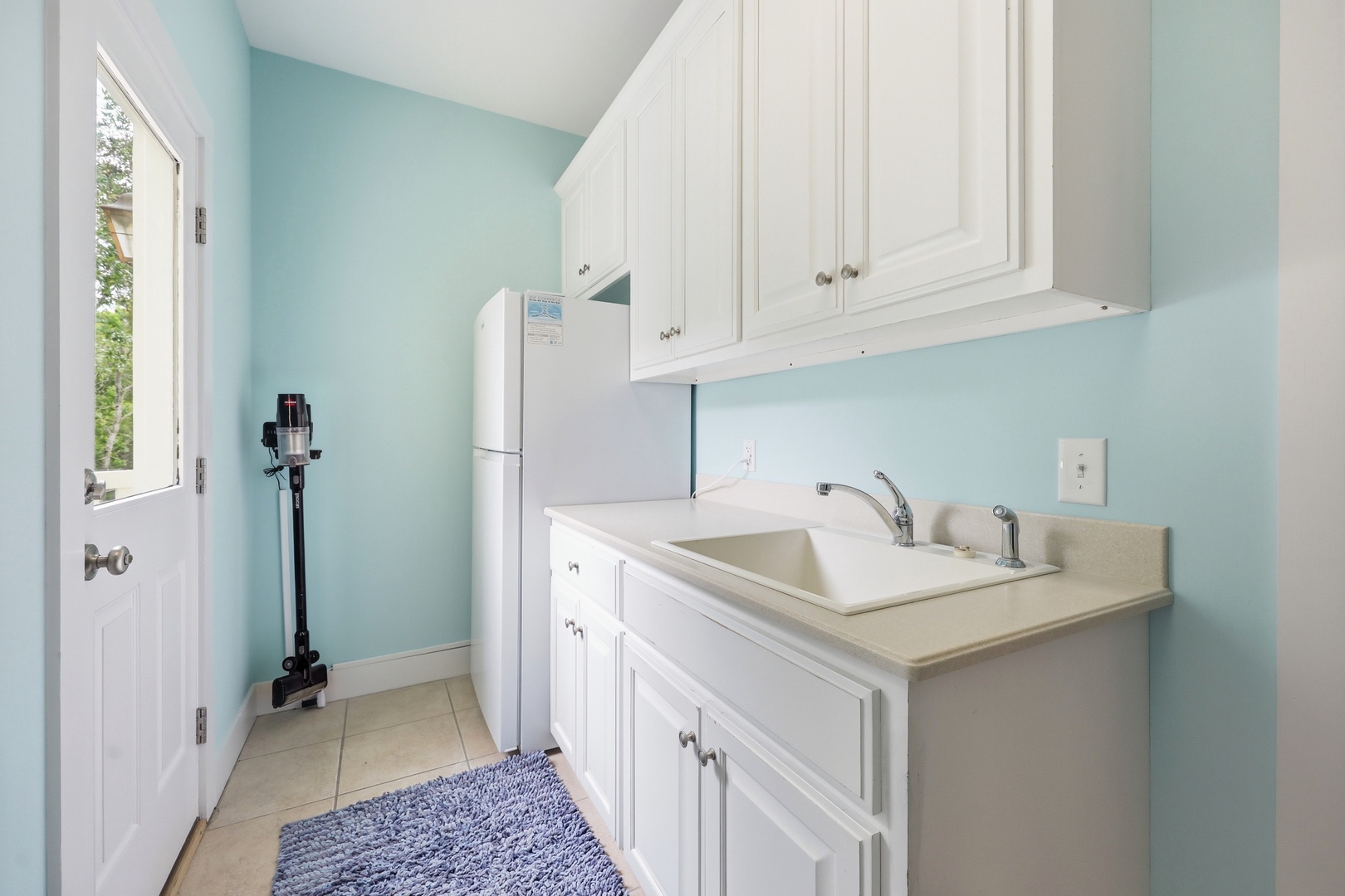 A practical laundry room with modern appliances and ample cabinet storage, making it easy to keep your wardrobe fresh during your stay.