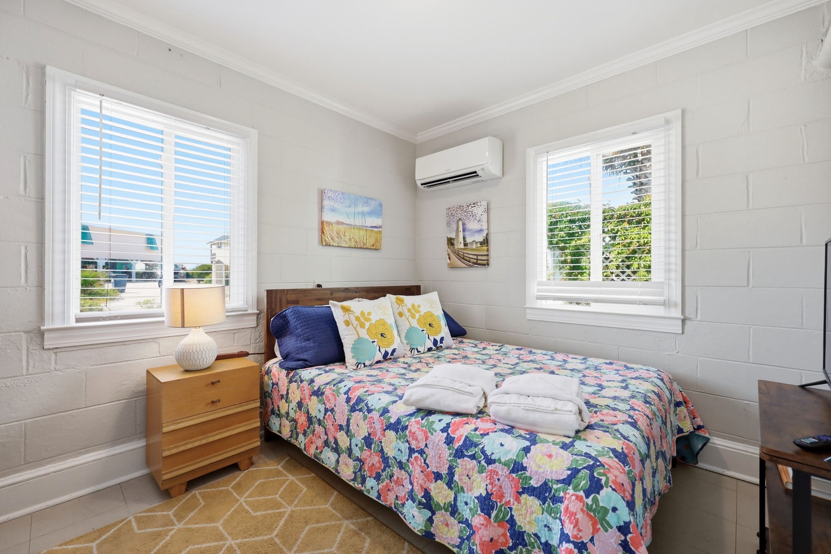 Slip into your cozy bedroom where soft linens, cheerful coastal accents, and gentle natural light create a peaceful retreat after a day of exploring.