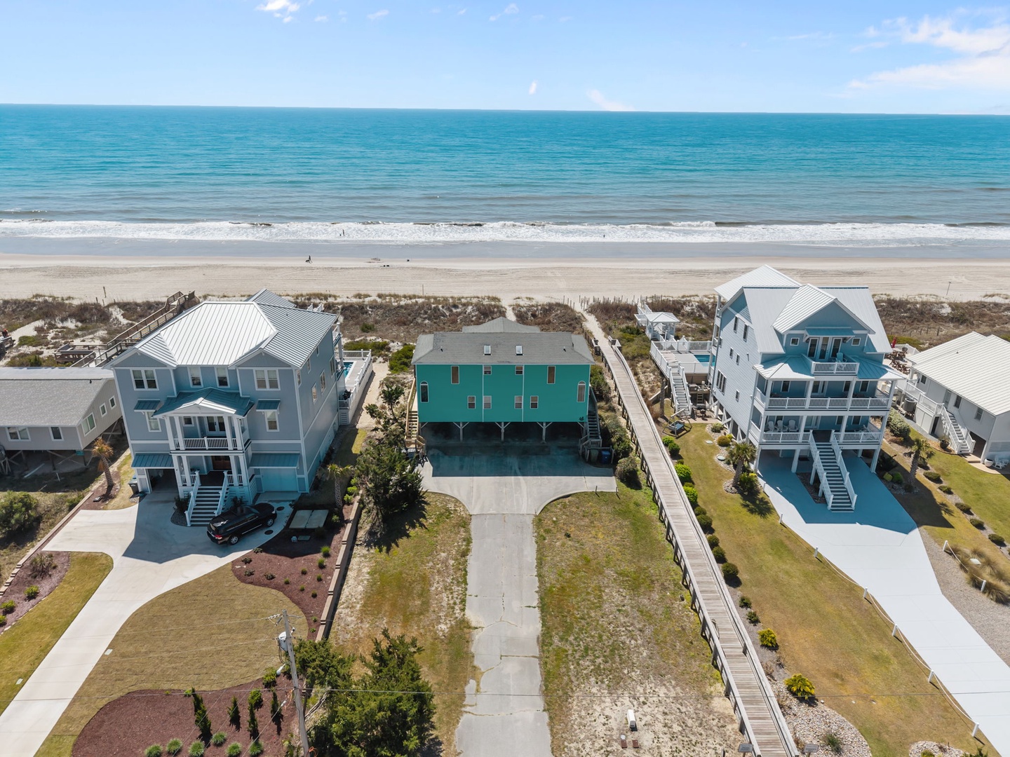 Oceanfront vacation homes positioned just steps from pristine sandy beaches with turquoise waters stretching to the horizon.