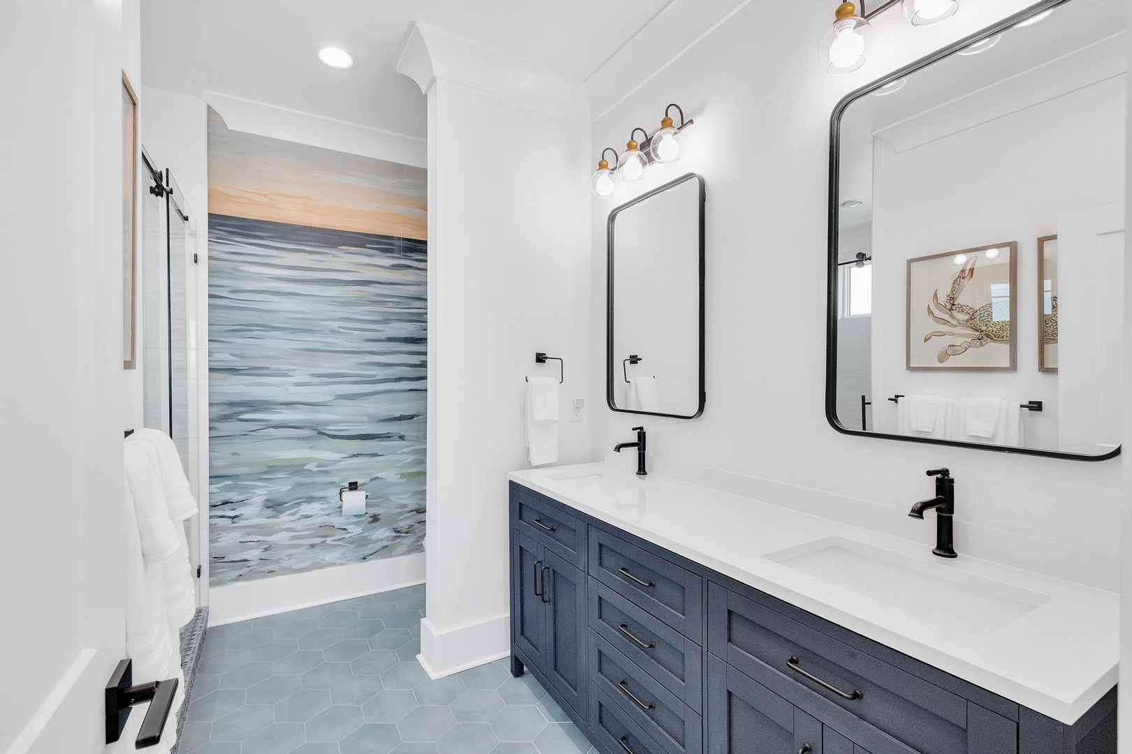 Your dual vanity features modern fixtures, crisp white counters, and coastal artwork that brings serene beachside vibes into your morning routine.