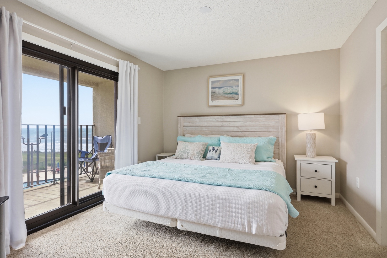Wake up to ocean breezes and step right onto your private balcony. This coastal bedroom invites you to unwind with soft linens, soothing colors, and your morning coffee just beyond the door.