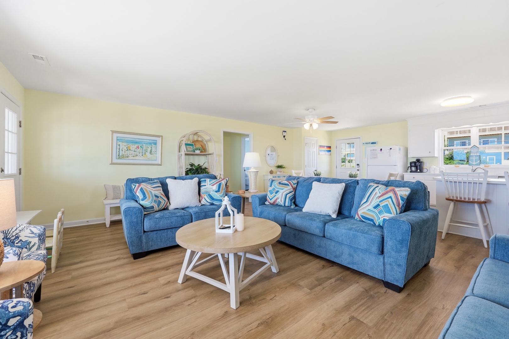 Step into your bright, cheerful living room where coastal blues meet buttery yellow walls. Sink into plush sofas, gather around the coffee table, and feel the ocean breeze from nearby waters.